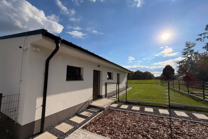 Dokončený bungalov v Krmelíně, pohled z boku na louku a les.